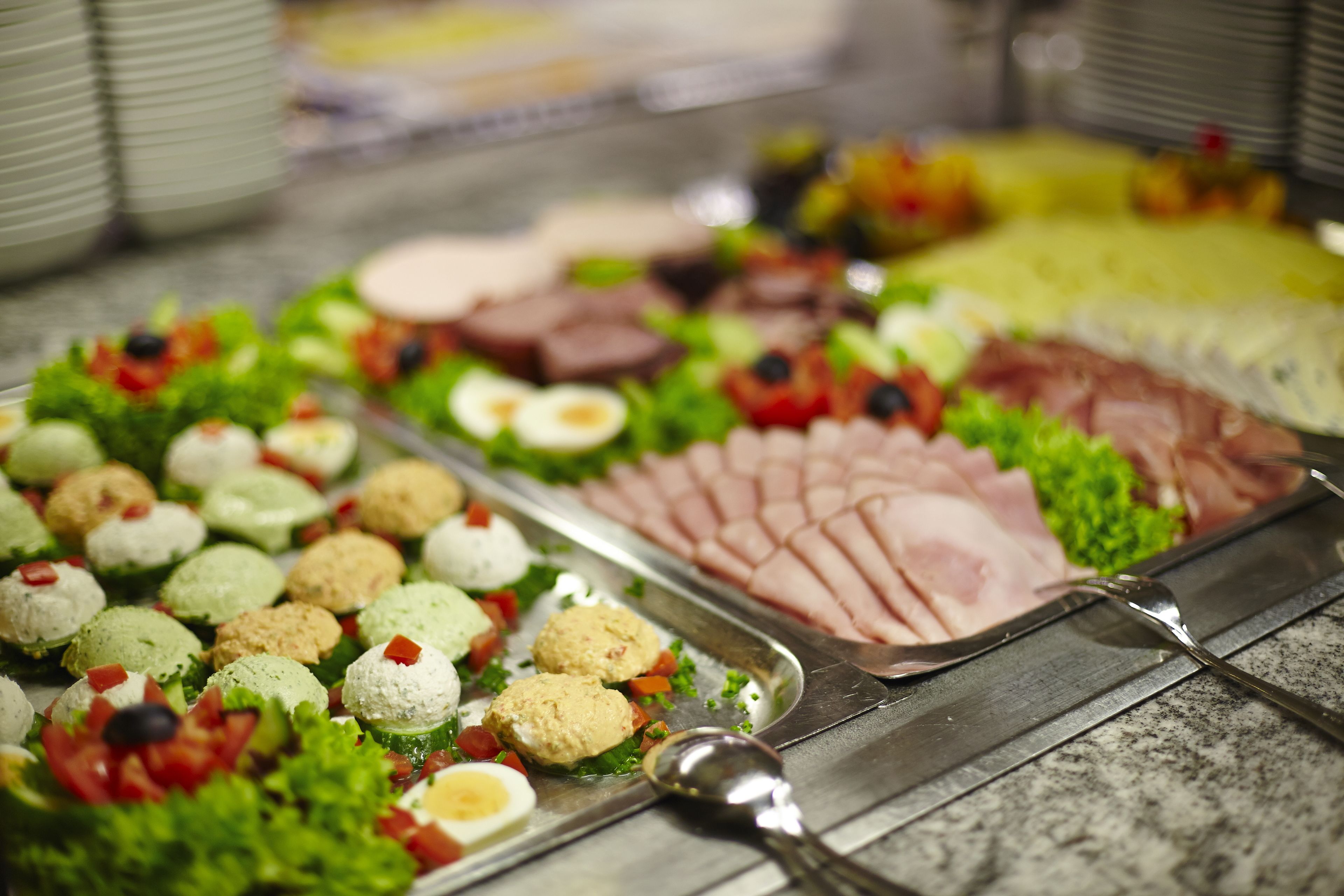 A buffet with various food items including salads, meats, and appetizers.