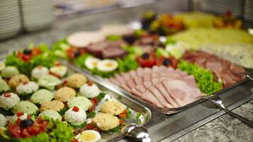 A buffet with various food items including salads, meats, and appetizers.