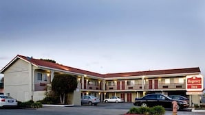 A motel with a two-story structure, multiple parking spaces, and a sign indicating it is a Rexall Inn. - Regency Inn SFO Airport (San Bruno)