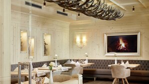 Un restaurante con paredes de paneles de madera, asientos acolchados y una pantalla grande que muestra un fuego.