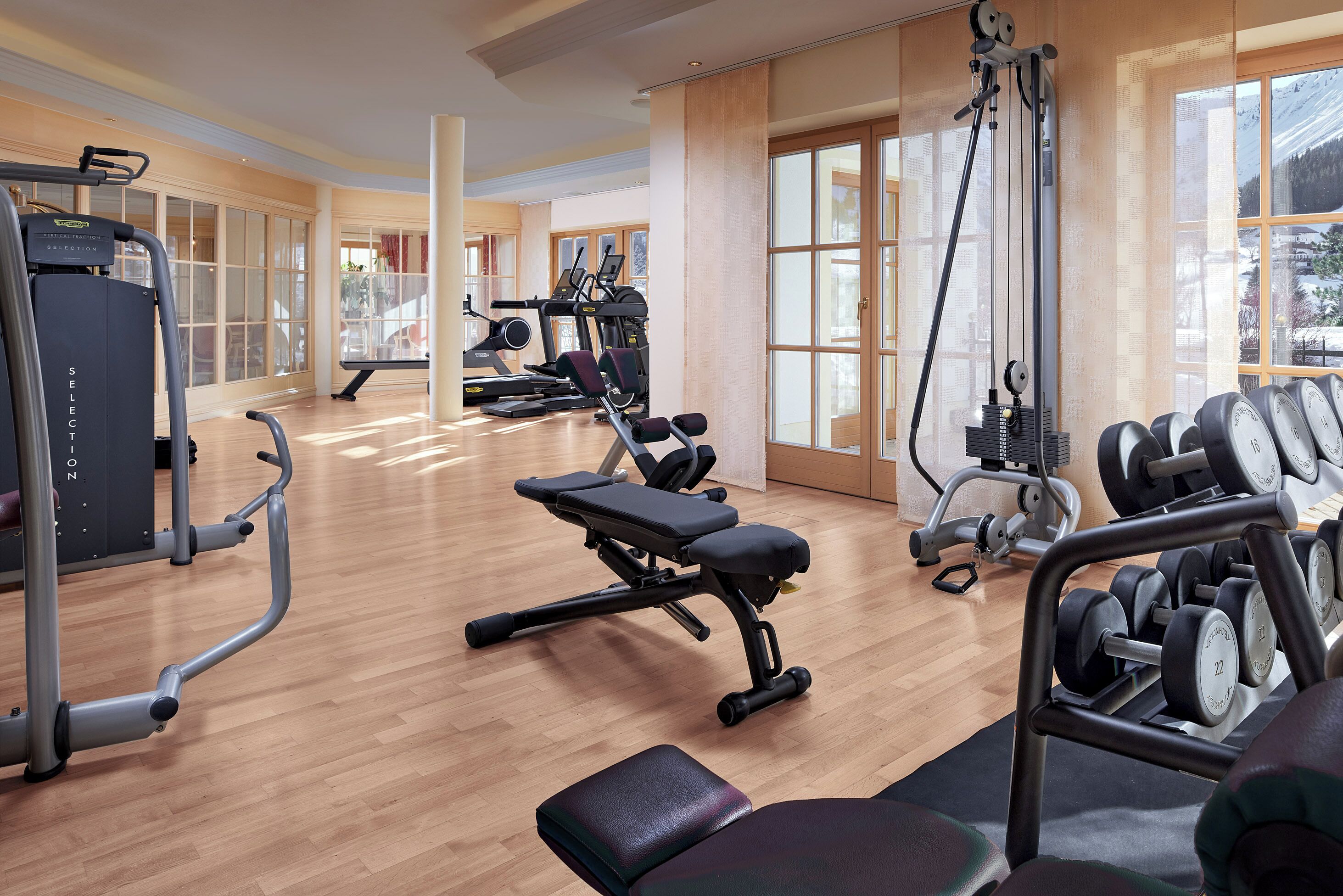 Une salle de sport équipée de machines de cardio, de bancs de musculation et d’haltères.