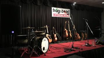 A stage with musical instruments and a sign that reads "frog & toad Listening Room".