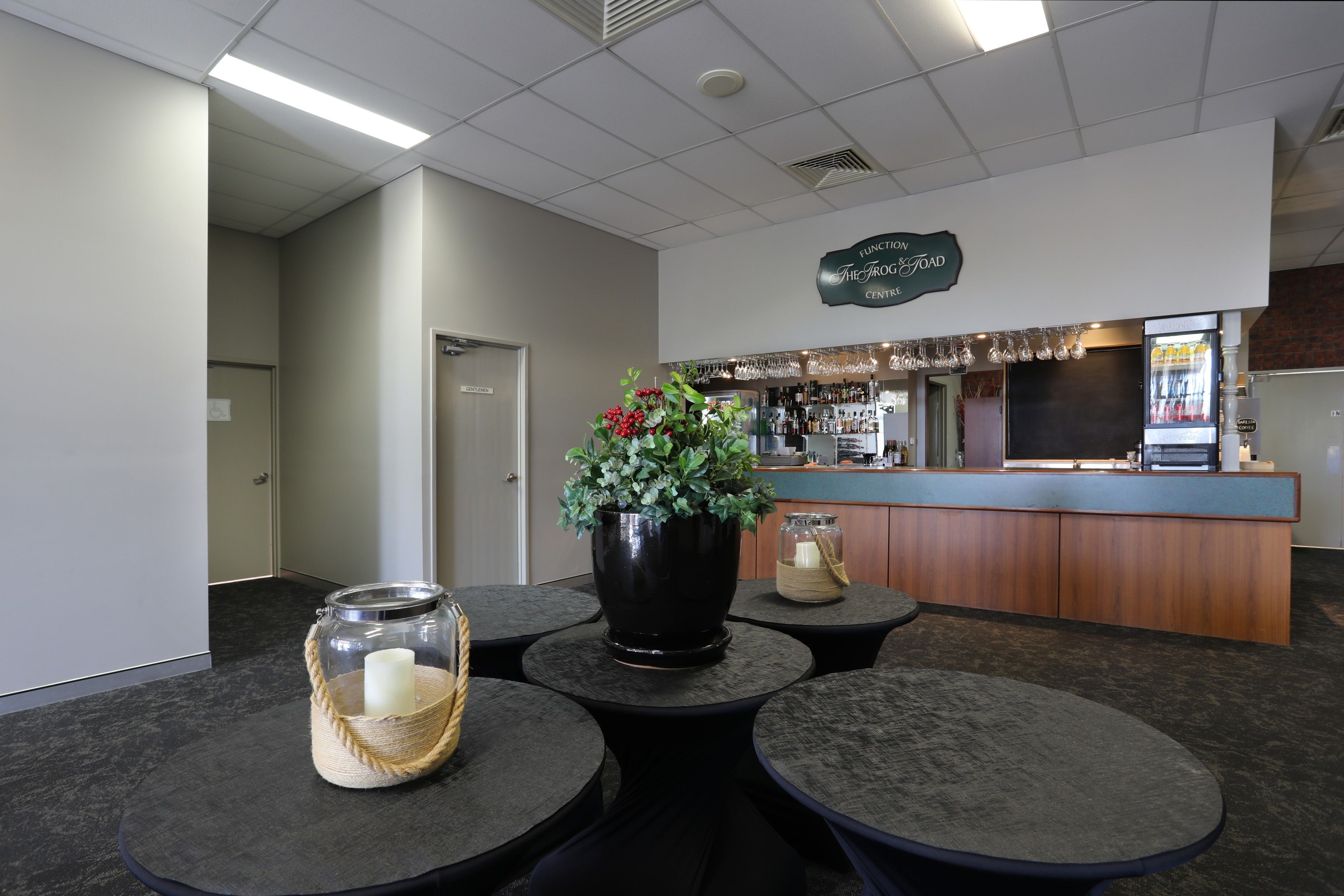 A reception area with a counter, a potted plant, and a glass jar with a candle.