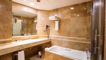 Un baño moderno con dos lavamanos, un espejo grande, una ducha y una bañera.