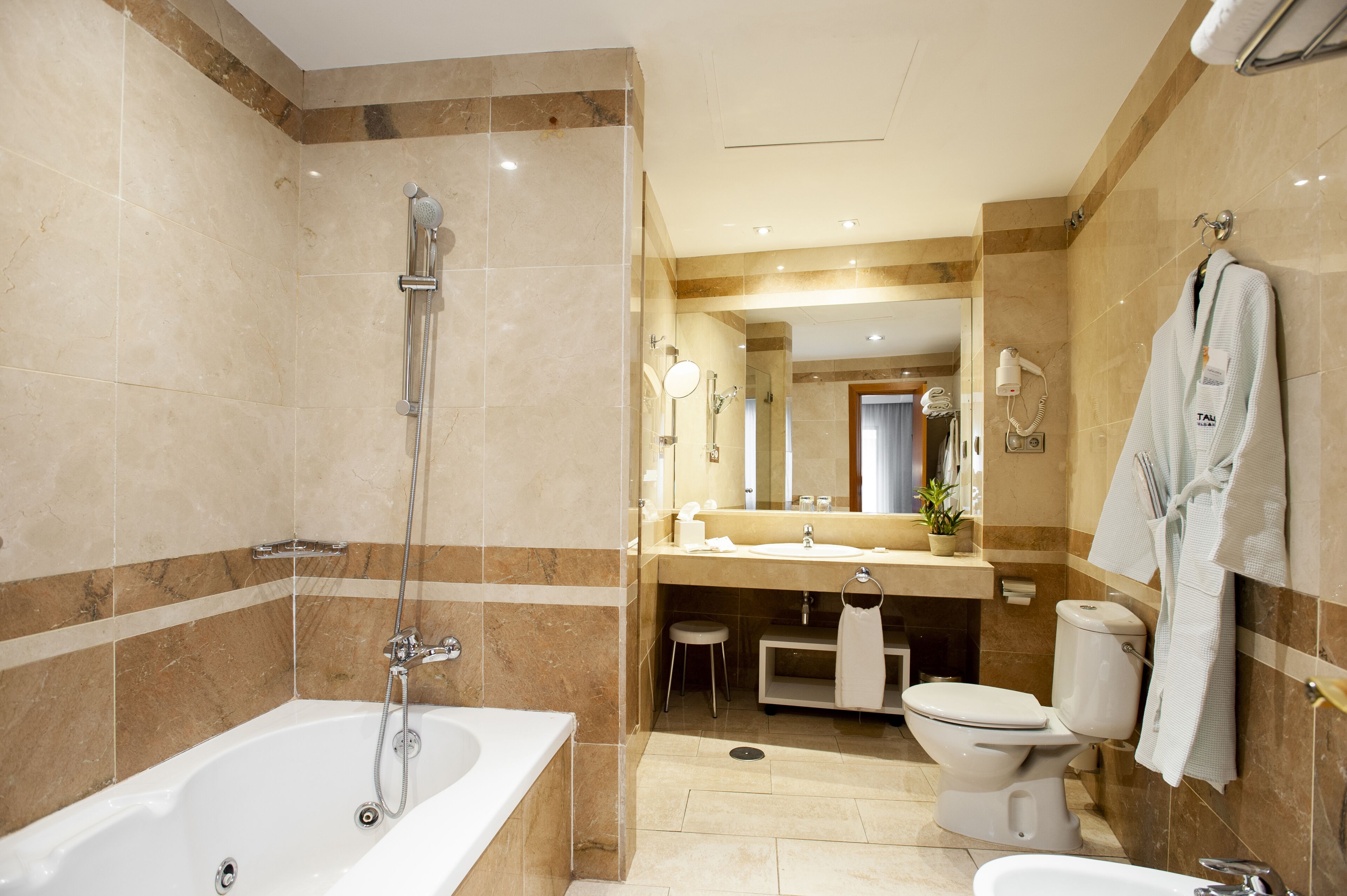 Une salle de bain moderne avec une baignoire, des toilettes et un lavabo.