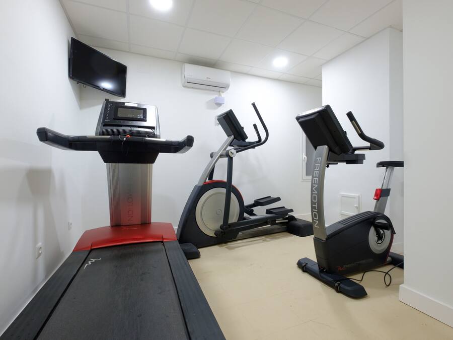 A home gym with treadmills and stationary bikes.