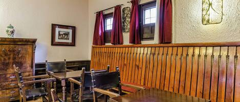 A dining area with wooden furniture, a wooden bench, and a wall-mounted decorative piece.