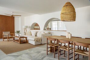 A modern living room with a sofa, coffee table, and dining table.