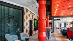 A modern interior with a bicycle, seating, and a prominent red pillar.