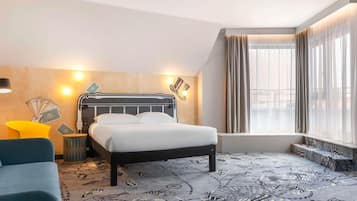 Een hotelkamer met een bed, een stoel, een nachtkastje en een raam met gordijnen.