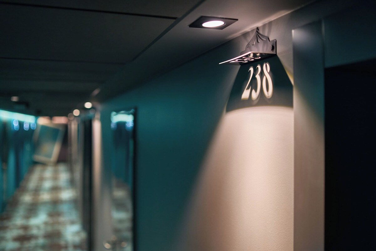 A hotel hallway with a number sign indicating room 238.