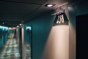 A hotel hallway with a number sign indicating room 238.