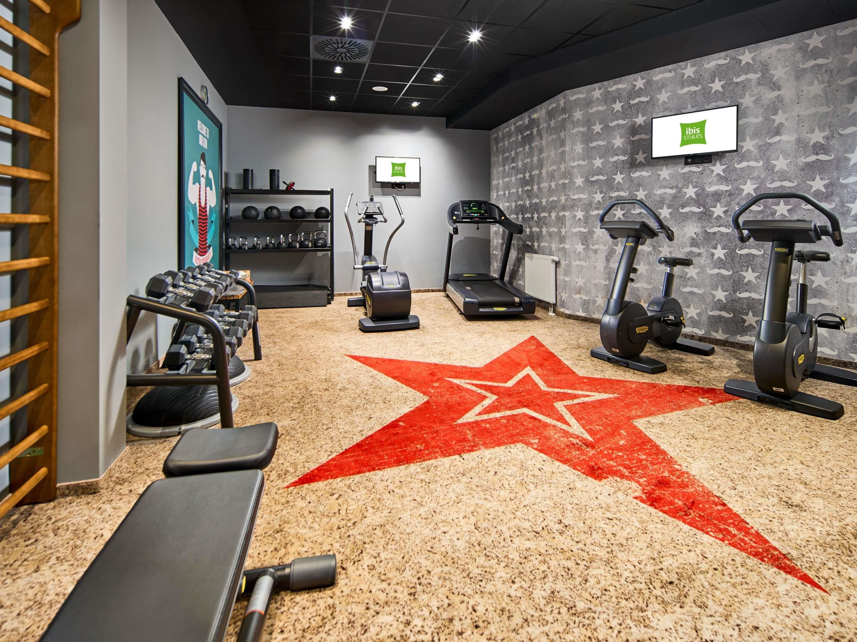 Ein Fitnessstudio mit Laufbändern, Crosstrainern und Gewichten.