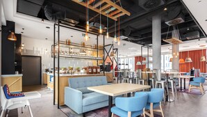 A modern interior with a bar area, seating, and a kitchenette. - ibis Styles Szczecin Stare Miasto (Szczecin)