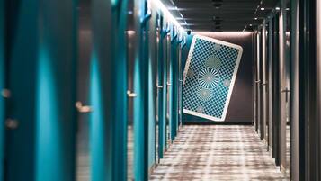 Un pasillo con puertas color turquesa y suelo estampado.