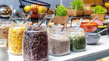 A buffet with various food items in jars and bowls, including cereals, nuts, and seeds.