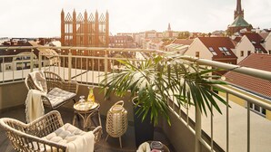 A balcony with wicker chairs, a small table, and a potted plant. - ibis Styles Szczecin Stare Miasto (Szczecin)
