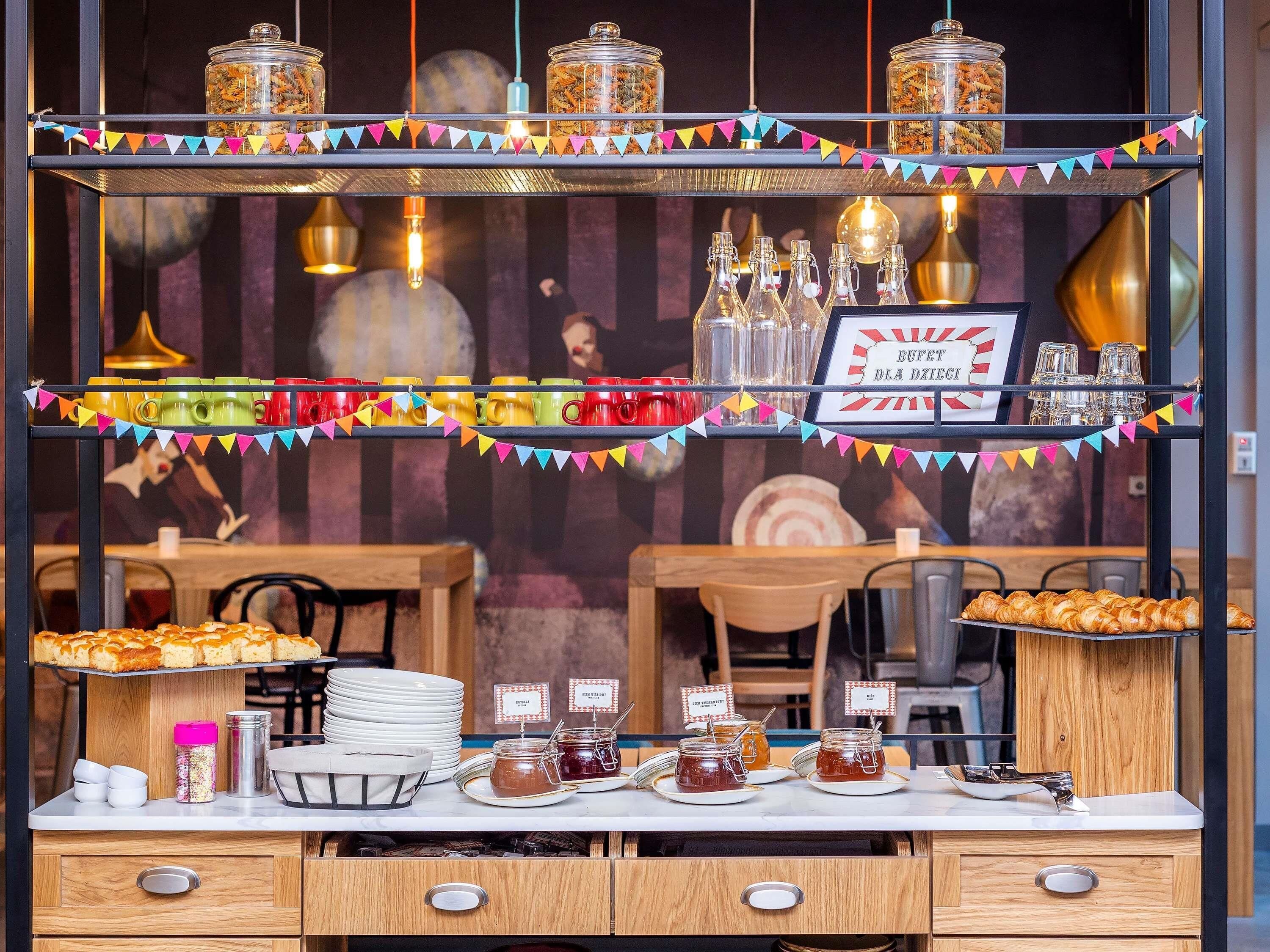 A buffet setup with jars of condiments, a tray of pastries, and a sign indicating a buffet area.