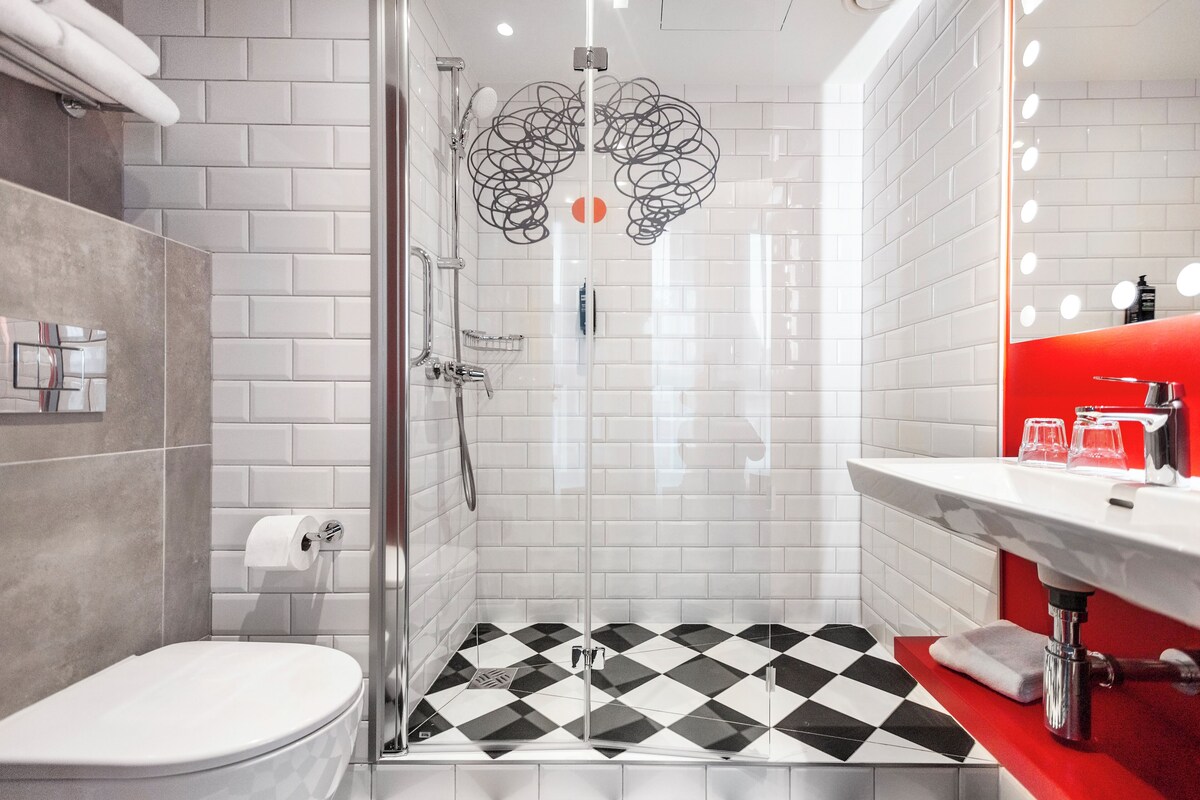 A modern bathroom with a shower, toilet, and sink.
