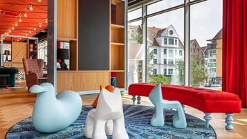A modern interior with a large window, a red bench, and unique animal-shaped stools.
