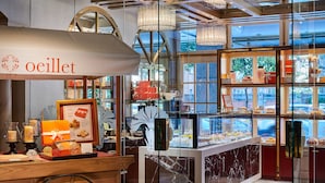 A bakery display with a sign reading "oeillet" and various baked goods on shelves. - The Riviera Hotel (Taipei)