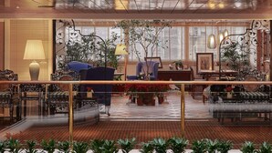 A hotel lobby with a central seating area, a reception desk, and a view of the city through large windows. - The Riviera Hotel (Taipei)