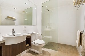 A modern bathroom with a sink, toilet, and glass-enclosed shower. - Karratha International Hotel (Pegs Creek)