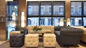 A modern living room with a sofa set, ottomans, and a coffee table.