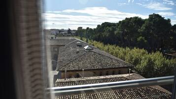 A view of a building with a tiled roof and a series of windows.