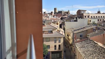 A view of a cityscape with traditional architecture, including a prominent tower and a mix of residential and commercial buildings.