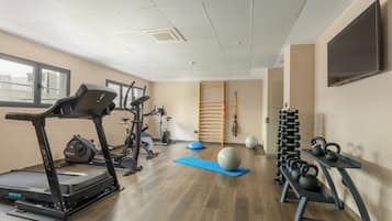 A gym with treadmills, exercise balls, and kettlebells.