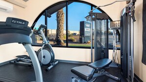 A gym with a treadmill, exercise bike, and weight machines. - Hotel McCoy Tucson - Art, Coffee, Beer, Wine (Tucson)