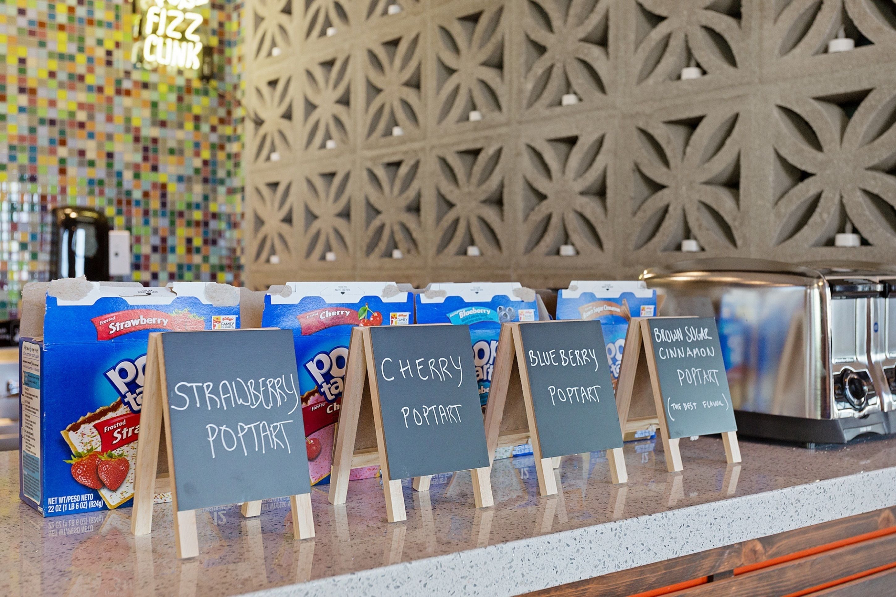 A dessert display with various flavors of poptart and a coffee machine in the background.