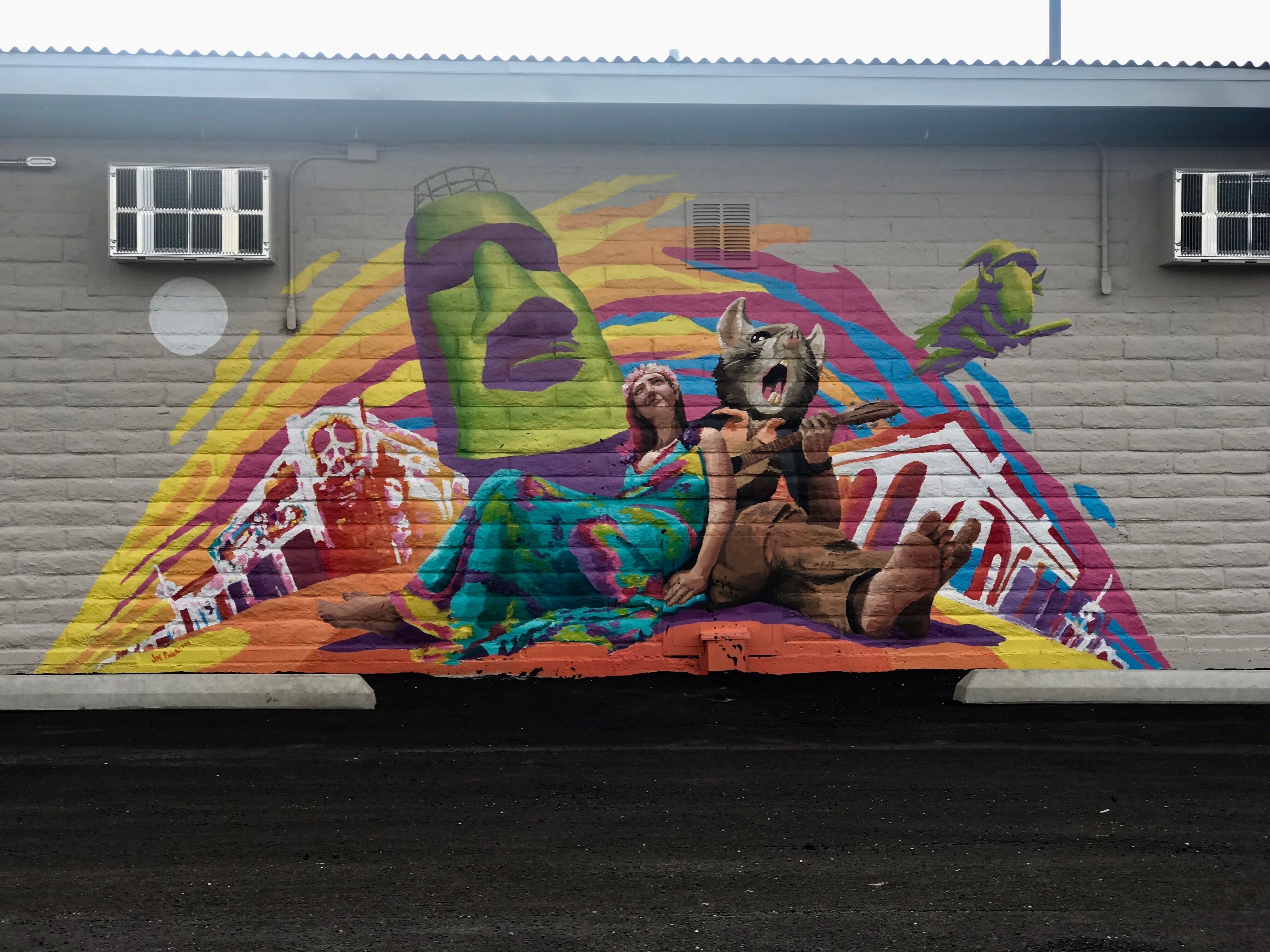Une fresque colorée orne le mur d’un immeuble.
