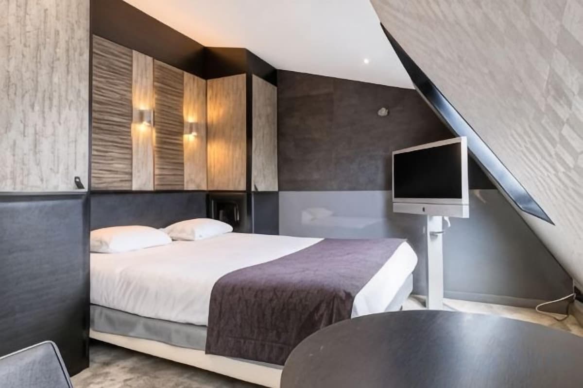 Un dormitorio moderno con cama, mesitas de noche, un televisor de pantalla plana y un amplio ventanal.