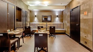 A hotel lobby with a seating area, tables, and chairs. - L'adresse (Paris)