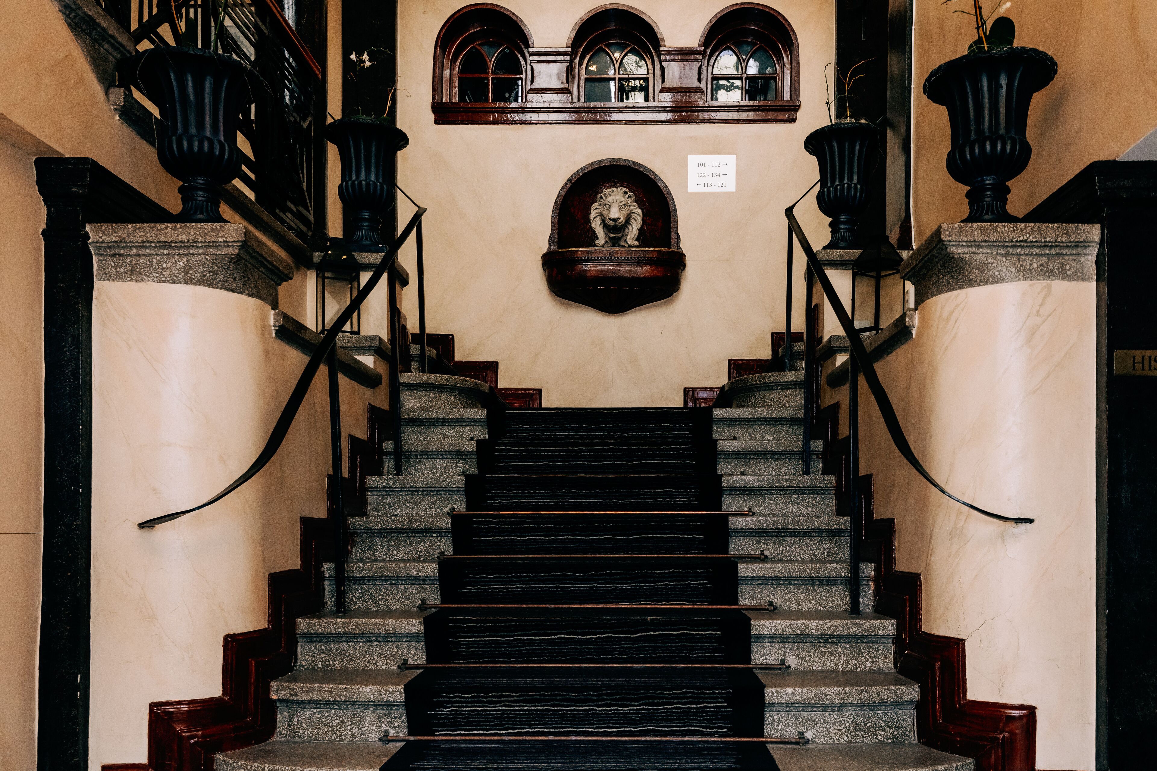 A grand staircase with ornate railings and a decorative lion head at the top.