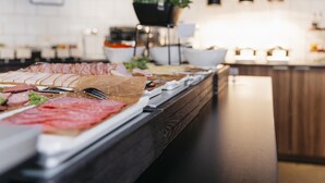 A buffet with various meats and a potted plant in the background. - Best Western Plus JA Hotel Karlskrona (Karlskrona)