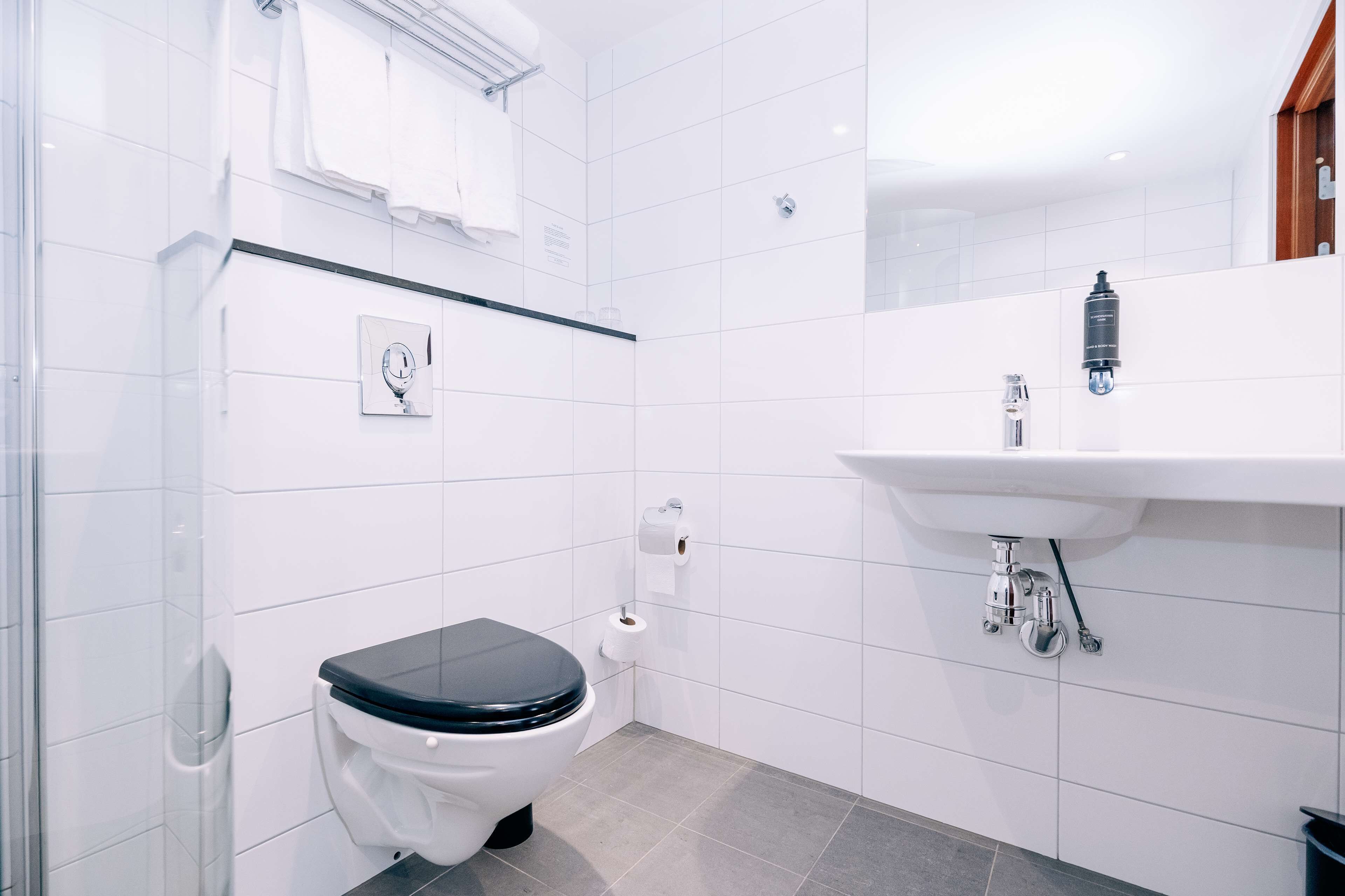 A modern bathroom with a toilet, sink, and shower area.