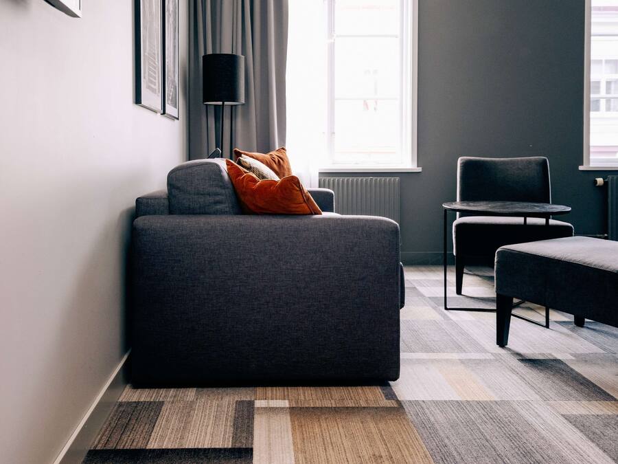 A modern living room with a grey sofa, a small round table, and a chair.