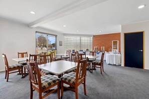 A conference room with tables and chairs, a window with a view, and a door. - Comfort Inn Lady Augusta (Swan Hill)