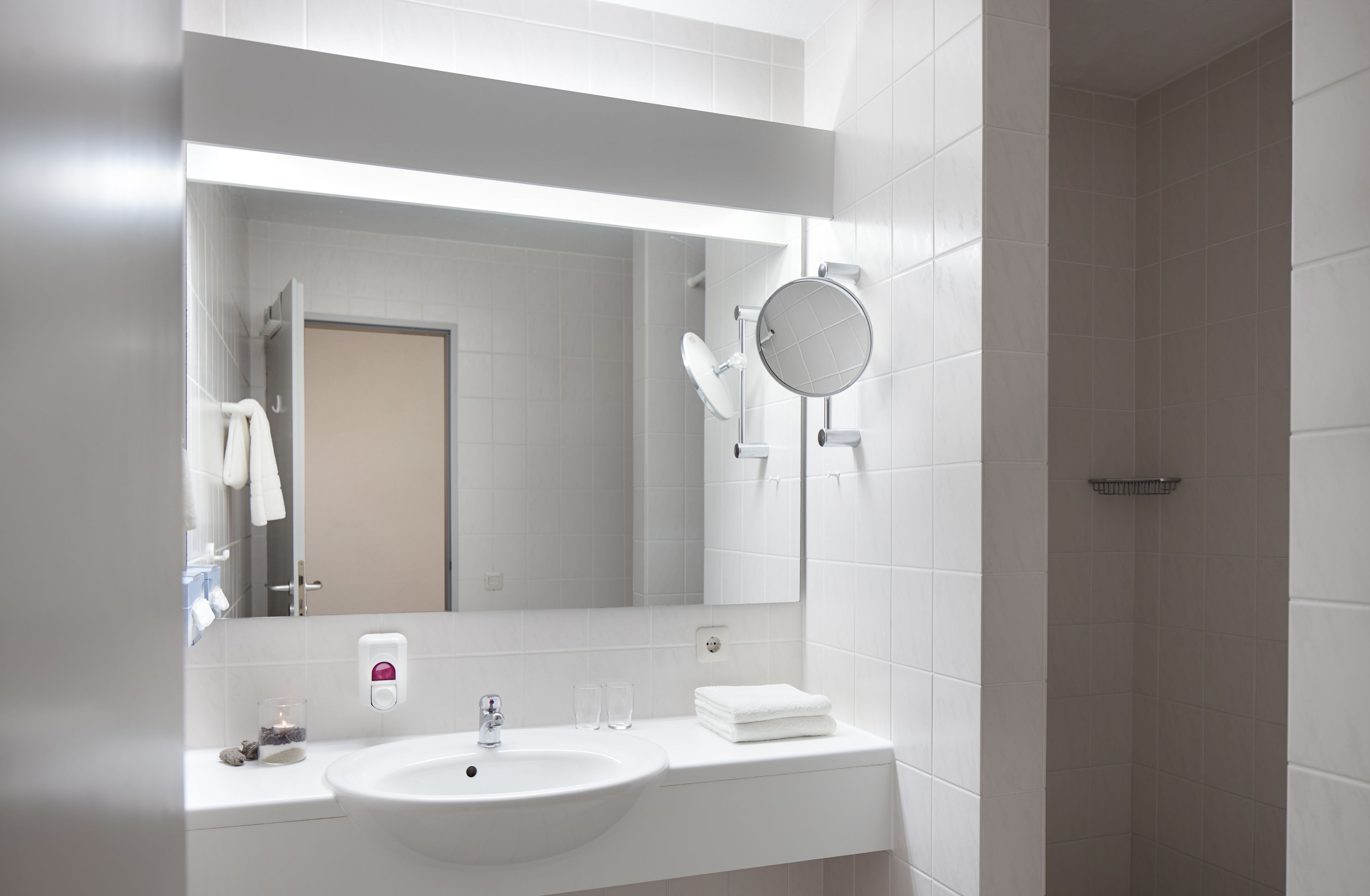 Ein modernes Badezimmer mit Waschbecken, Spiegel und Handtuchhalter.