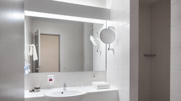 Ein modernes Badezimmer mit Waschbecken, Spiegel und Handtuchhalter.