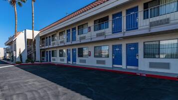 A motel with multiple rooms, a fire lane, and a clear sky.