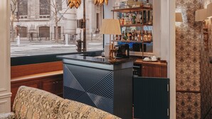 Eine Bar mit Blick auf ein historisches Gebäude, ein gemustertes Sofa und eine Wand mit Muster.