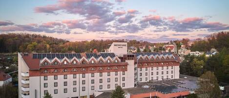 Un hotel de varios pisos, con un letrero llamativo y paneles solares en el techo.