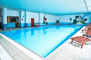 Una piscina techada, sillones reclinables de piscina