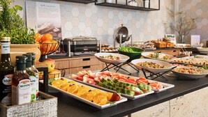 A buffet with various food items and a kitchen area with appliances.