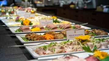 A buffet table with various food items and labels indicating different regional dishes.