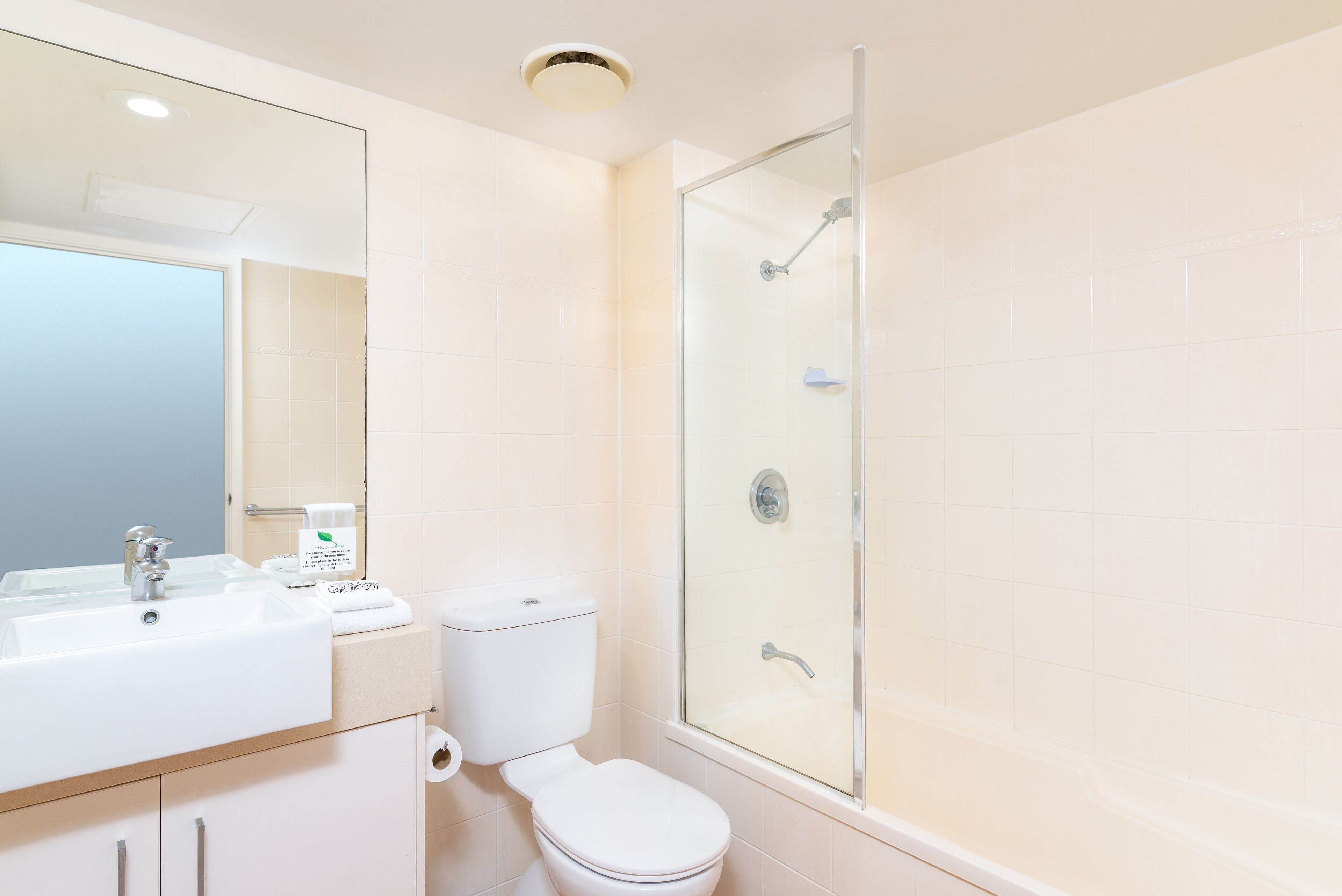 Une salle de bain moderne avec une douche à parois de verre, un lavabo blanc et des toilettes.